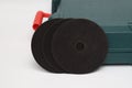 Abrasive black wheel, grinding wheel on the background of the green toolbox. Abrasive materials, discs, tools Royalty Free Stock Photo
