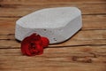 An abrasive stone to remove dry skin from heel with a red flower