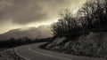 Abrupt turn of mountain road among the bare autumn wood