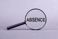 Absence word through magnifying glass on gray background