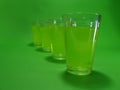 Absinthein a transparent glass on a green background Royalty Free Stock Photo