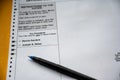 unfilled out absentee Democratic primary ballot with a pen ready to use.