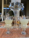 Absinth fountain with water and ice cube and four glasses and spoon Royalty Free Stock Photo