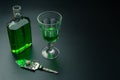 A glass of absinthe and a stainless steel slotted spoon with the sugar cube