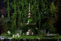 absinthe drip fountain against a lush green backdrop