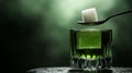 Absinthe preparation with spoon and sugar cube over green liquor. Royalty Free Stock Photo