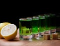Absinthe shot glass sugar lemon wooden table Royalty Free Stock Photo