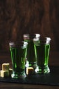 Absinthe - strong alcoholic drink, green bitter wormwood tincture in glasses on the old wooden table, place for text