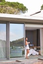 This is absolute bliss. Young attractive woman soaking up the morning sun on her balcony.