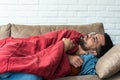 Absolute solitude. Side view of a depressed unhappy sad man lying on the sofa and hugging a blanket while feeling lonely, sad and Royalty Free Stock Photo