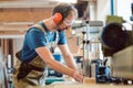 Absorbed carpenter at the milling machine working on wood Royalty Free Stock Photo