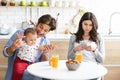 Absorbed woman browsing on phone, ignoring her family