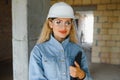 Absorbed in the work of a woman engineer working with a tablet on the background of the construction site. Portrait of a Royalty Free Stock Photo