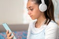 Absorbed young teenage girl listening to music on her mobile