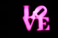 Abstact blurred Plastic pink sign of word LOVE on black background. Royalty Free Stock Photo