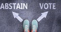 Abstain and vote as different choices in life - pictured as words Abstain, vote on a road to symbolize making decision and picking