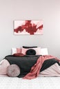 Abstract amaranth and pastel pink painting above king size bed with pink and black bedding