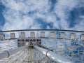 Abstract angle view of a giant ferris wheel with a blue winter sky in the background