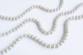 Abstract arranged three rows of natural pale pearl necklace on white