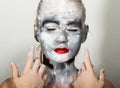 Abstract art makeup. Face and neck girls smeared with gray colors and bright red lips. Holi Festival Royalty Free Stock Photo