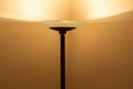 Art view of a modern pole lamp casting light upon a wall corner Royalty Free Stock Photo