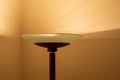 Art view of a modern pole lamp casting light upon a wall corner Royalty Free Stock Photo