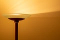 Art view of a modern pole lamp casting light upon a wall corner Royalty Free Stock Photo