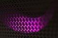 Abstract background of a black patterned lattice behind which purple LEDs glow Royalty Free Stock Photo