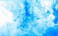 Abstract background. Blue ink in water, in motion. Color drop swirling. Colorful cloud of paint on white.