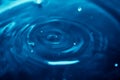 Abstract background with blue liquid ripples and drops, and light reflection, blurred background