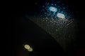 abstract background from blurry light from headlights on wet car windshield