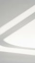 Abstract background of clean white surface with soft diagonal light and shadow stripes creating geometric shapes and lines Royalty Free Stock Photo