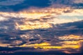 Abstract background of colorful dramatic sky in twilight, with storm clouds, golden, grey and orange, and sunlight breaking Royalty Free Stock Photo