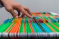 Abstract background colorful hanging file folders in drawer. Mans hand Search document