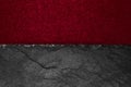 Abstract background composition of divided in the half matt vivid burgundy color paper and black stone with copy space