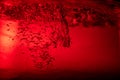 Air bubbles in water under red lighting Royalty Free Stock Photo