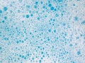 Abstract background with detergent bubbles on water surface in blue bath to cleaning. Royalty Free Stock Photo
