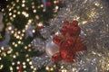 Abstract background of glittering bokeh lights with blurred ornament on the silver Christmas tree in foreground Royalty Free Stock Photo