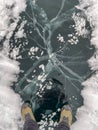 The natural texture of winter ice with white bubbles and cracks on a frozen lake. Abstract background of ice and cracks on the Royalty Free Stock Photo