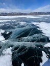 The natural texture of winter ice with white bubbles and cracks on a frozen lake. Abstract background of ice and cracks on the Royalty Free Stock Photo