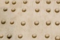 Abstract background industrial metal base beige surface rivets row uneven surface