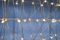 abstract background is a metal structure made of thin rods with light bulbs in a geometric sequence. strange art objects Royalty Free Stock Photo