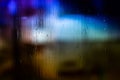 An abstract background night street lights bokeh through wet glass with water drops, close-up with selective focus Royalty Free Stock Photo