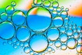 Abstract Background of Oil Bubbles on Water Surface cyan orange green colorful palette Royalty Free Stock Photo