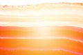 Abstract background, red and orange agate striped mineral cross section with sunbeam