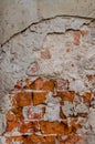 Abstract background - shabby shabby plaster on a brick wall a wall, through the red plaster a red brick breaks through