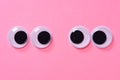 Googly eyes of pair of lovers on rose background. Close up. Royalty Free Stock Photo