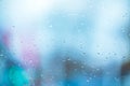 Abstract background with the texture of raindrops on the misted glass of a window with blue illumination in damp chilly weather