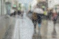 Abstract background of two young people under umbrella, walk on road in city in rain. Water drops on glass. Intentional Royalty Free Stock Photo