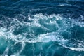 Abstract background. The waves of the sea water meet with underwater pointed rocks, forming whirlpools.